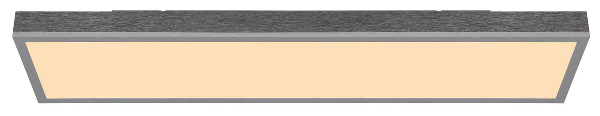 Vue de face du plafonnier allumé, diffuseur lumineux rectangulaire et bord argenté.