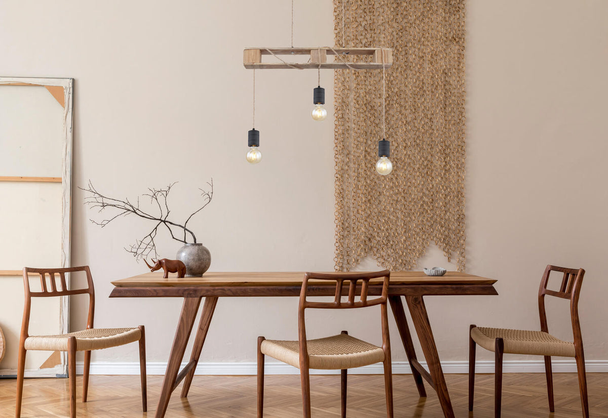 Mise en ambiance au-dessus d'une table en bois, suspension allumée dans salle à manger.