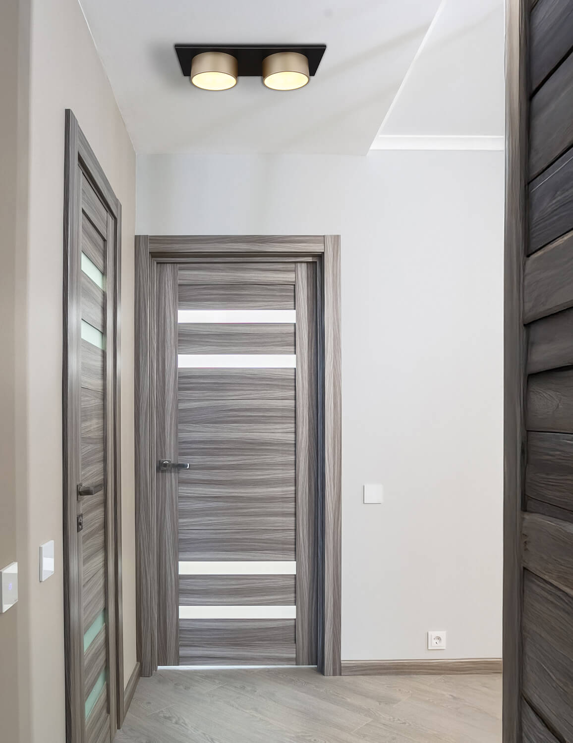 Mise en ambiance dans un couloir : plafonnier fixé au plafond, éclairant les portes et murs.