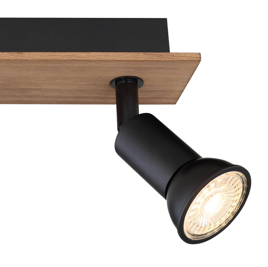 Détail d'un projecteur noir orientable et de la platine en bois avec verre strié.
