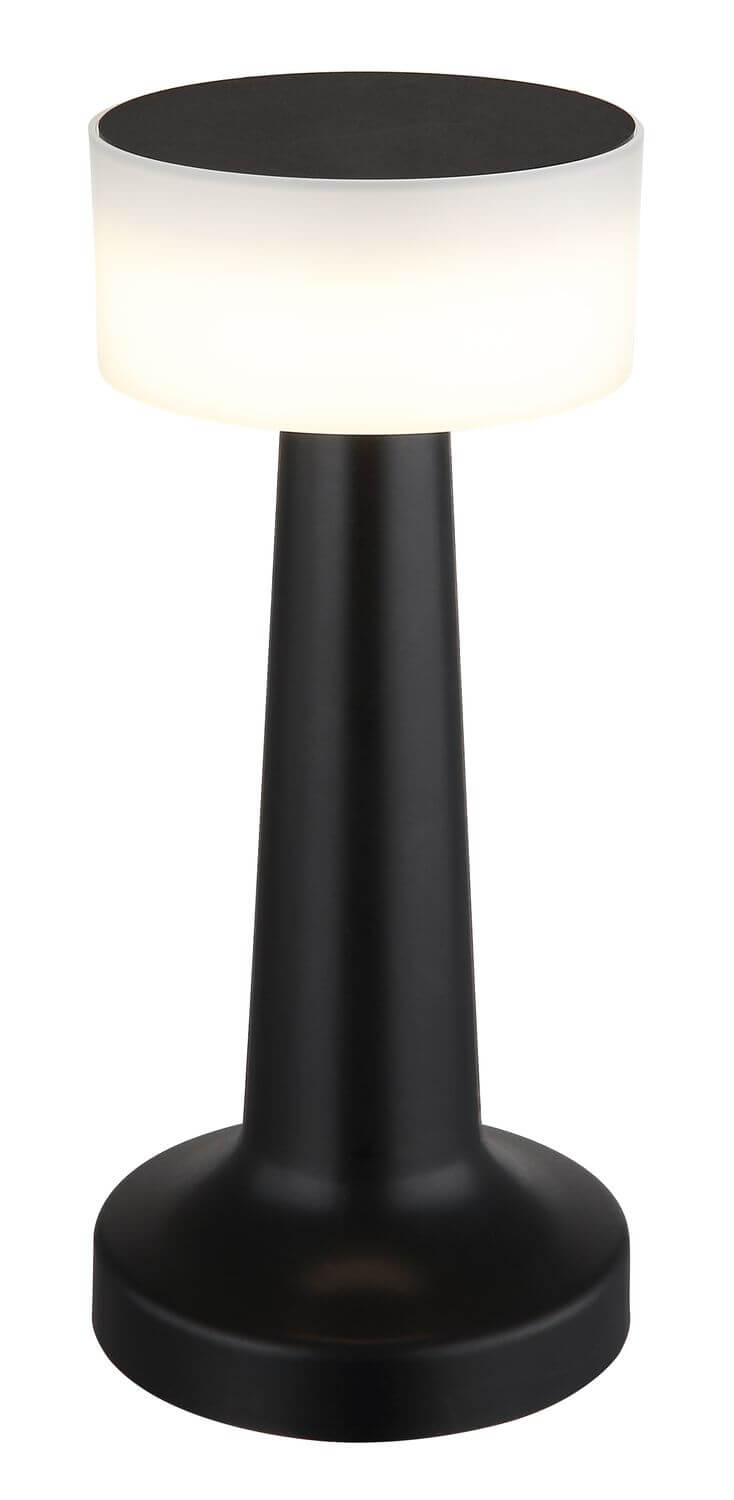 Vue rapprochée de la lampe allumée, abat-jour blanc et pied noir.