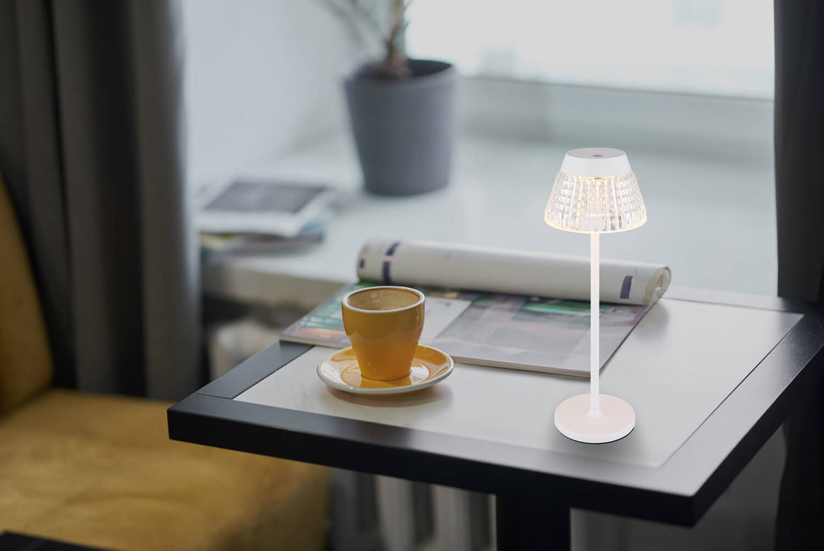 Mise en ambiance sur table basse avec tasse jaune et magazines près d'une fenêtre