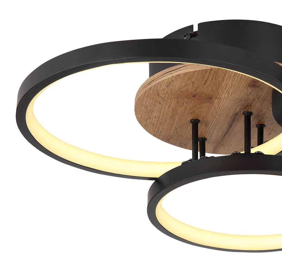 Détail rapproché de la structure métallique noire et du socle en bois.