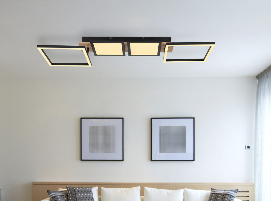 Mise en situation au plafond, luminaire allumé au-dessus d'un canapé et cadres muraux
