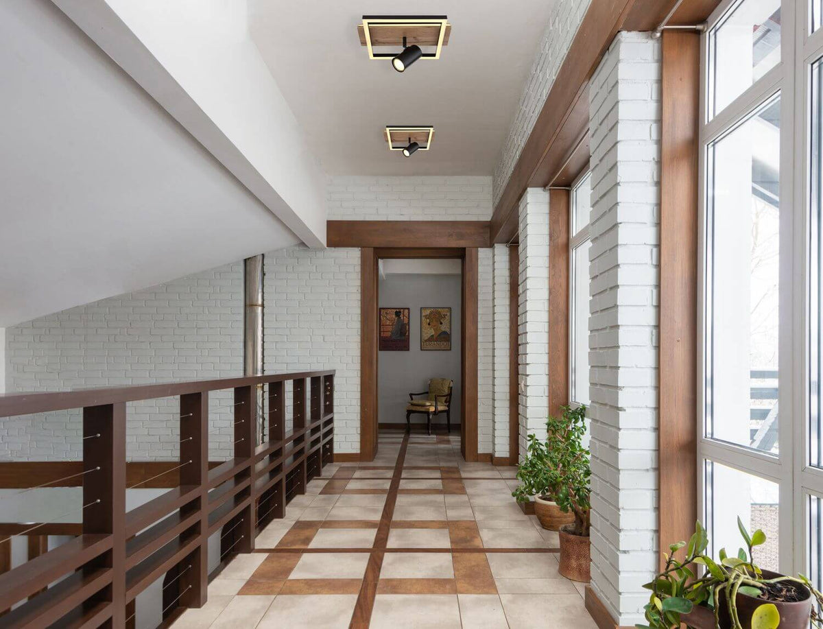 Mise en ambiance : deux plafonniers identiques éclairent un couloir blanc et boiseries.
