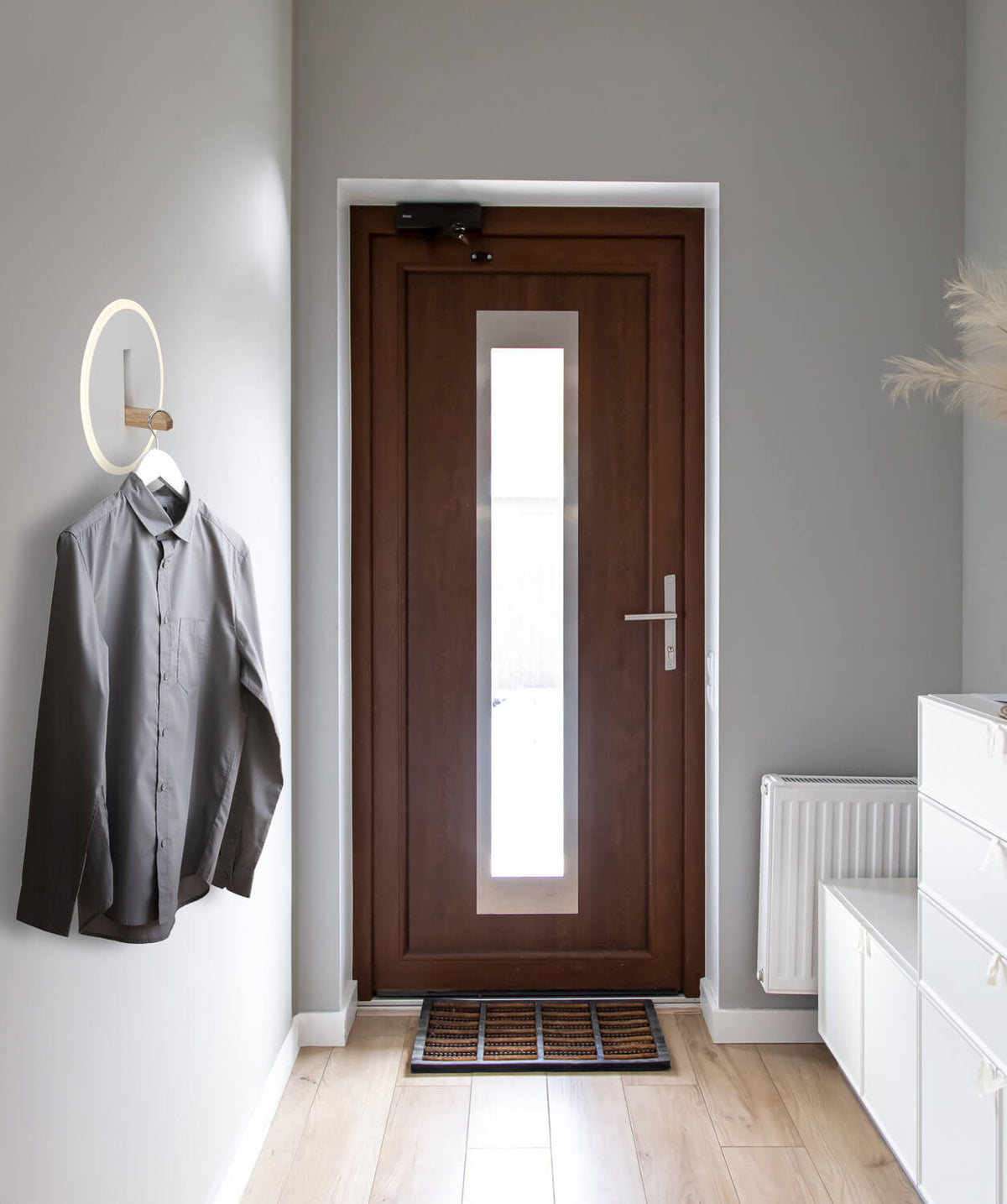 Mise en ambiance dans une entrée, applique utilisée comme porte-manteau mural