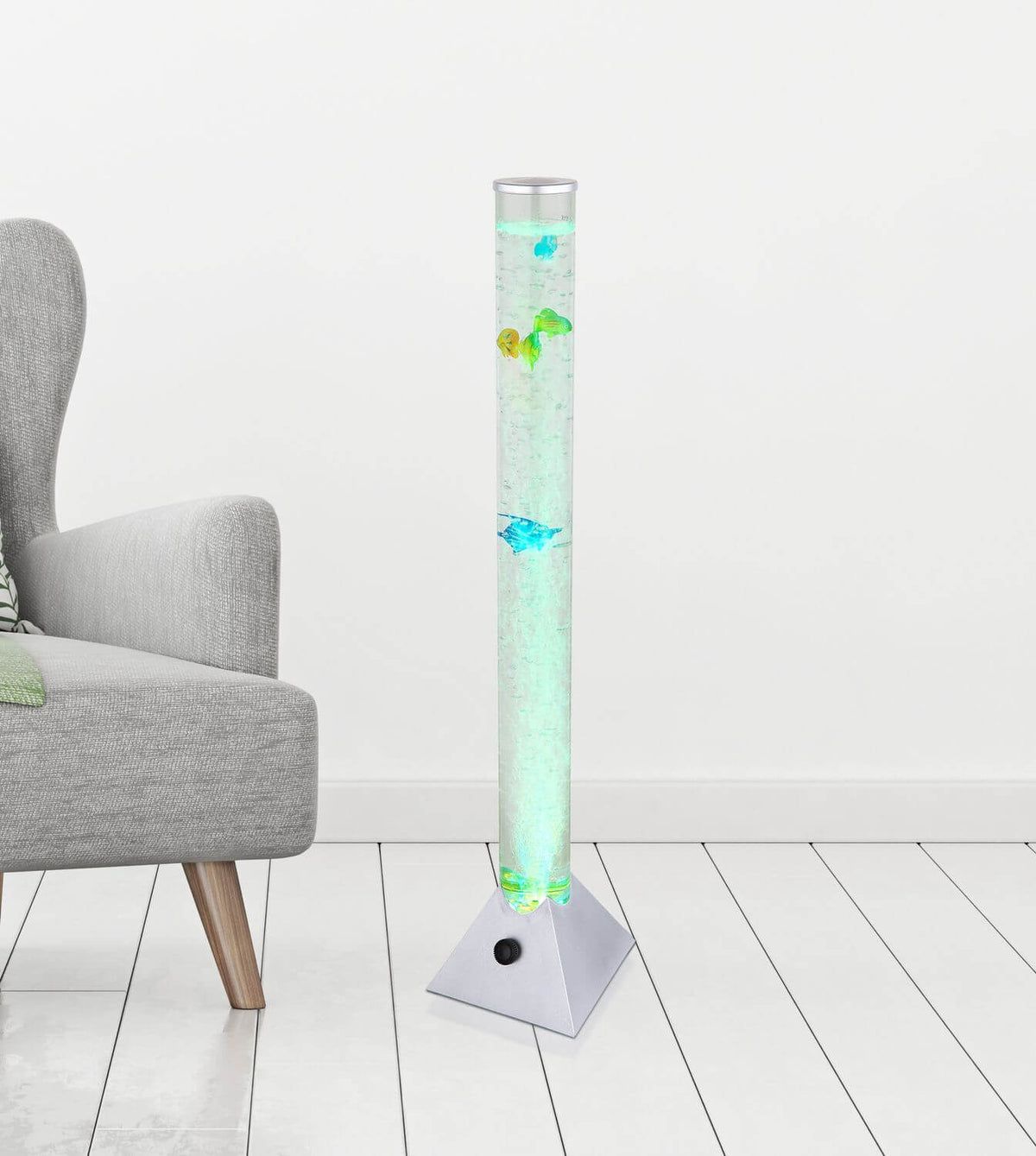 Mise en ambiance dans un salon, lampadaire allumé en vert près d'un fauteuil.