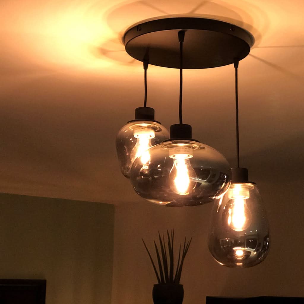 Lustre verre fumé 3 globes noir allumé au plafond, lumière tamisée