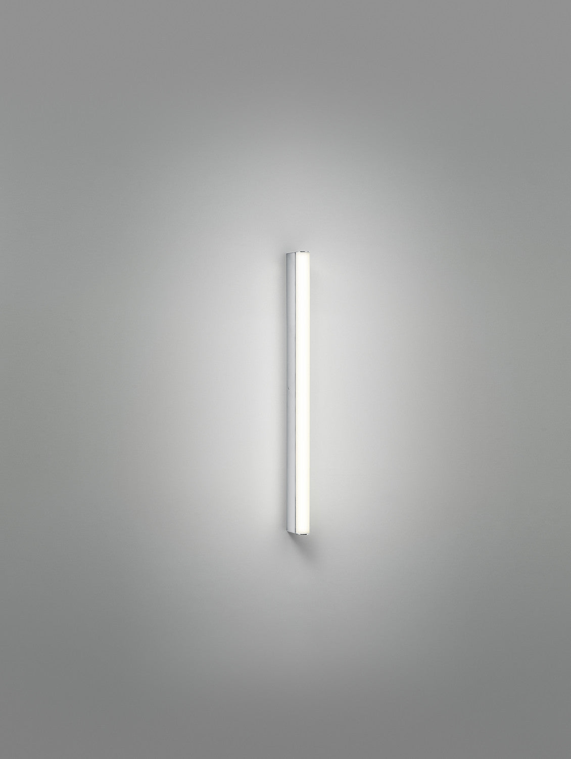 Photographie verticale du long tube lumineux seul sur fond gris uni