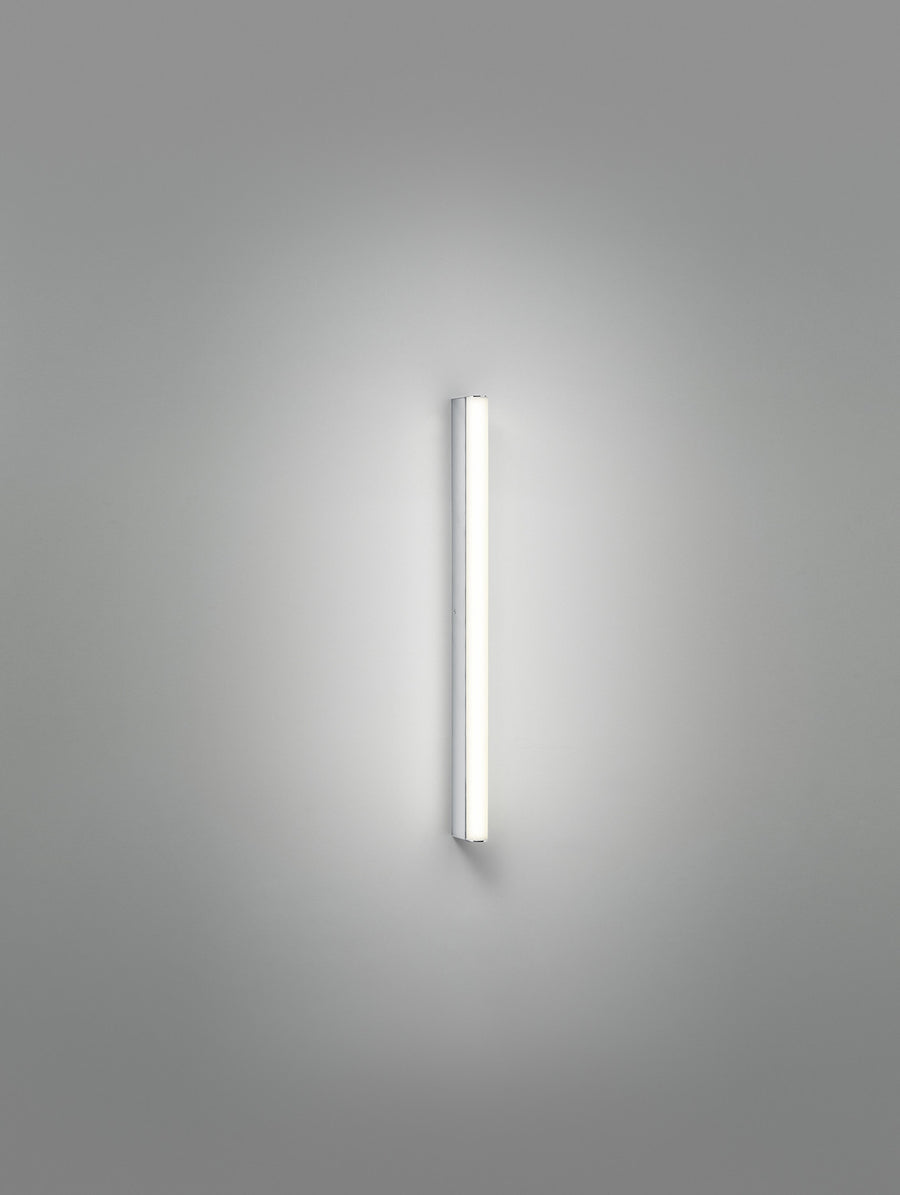 Photographie verticale du long tube lumineux seul sur fond gris uni