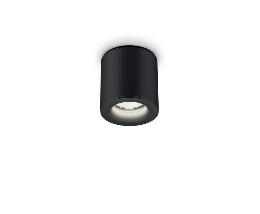 Vue de face du plafonnier cylindrique noir avec spot et ampoule visible.