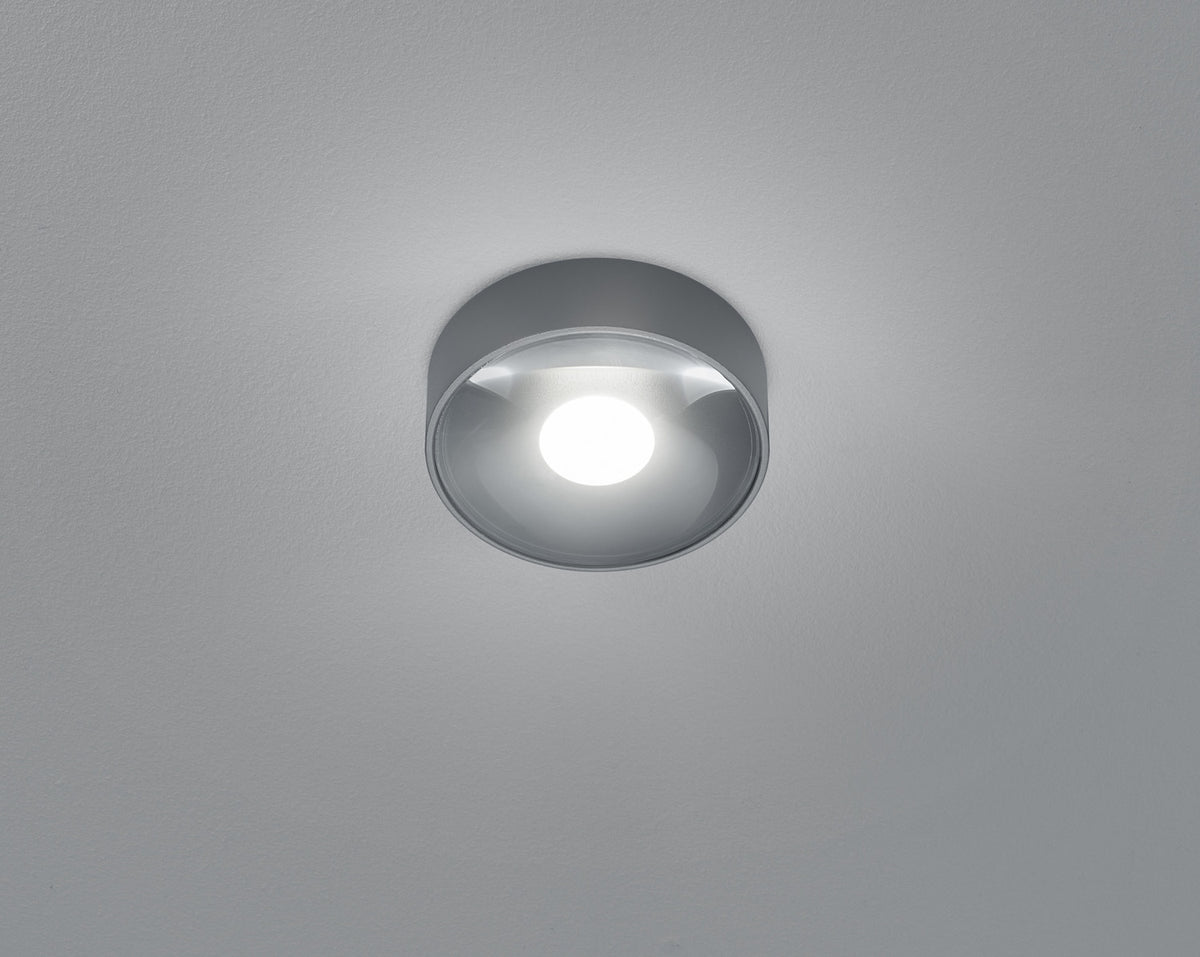 Vue rapprochée par dessous du plafonnier allumé, verre bombé et lumière blanche