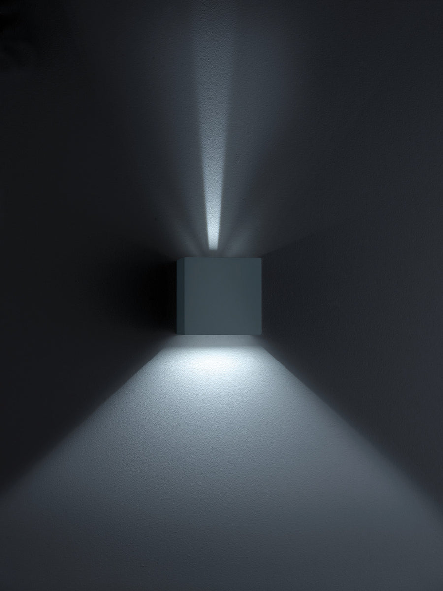 Applique noire carrée sur mur sombre, éclairage vers le haut et le bas