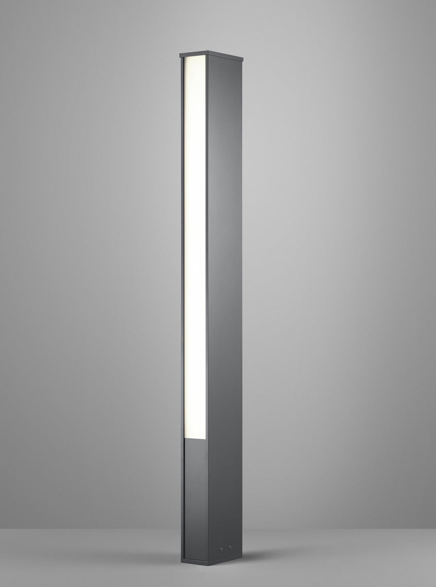 Vue de face du luminaire : longue bande lumineuse verticale et socle sombre
