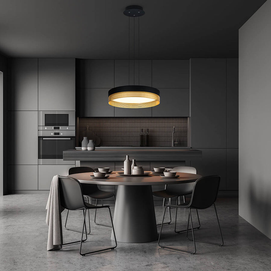 Suspension noire et dorée installée au-dessus d'une table de salle à manger moderne.