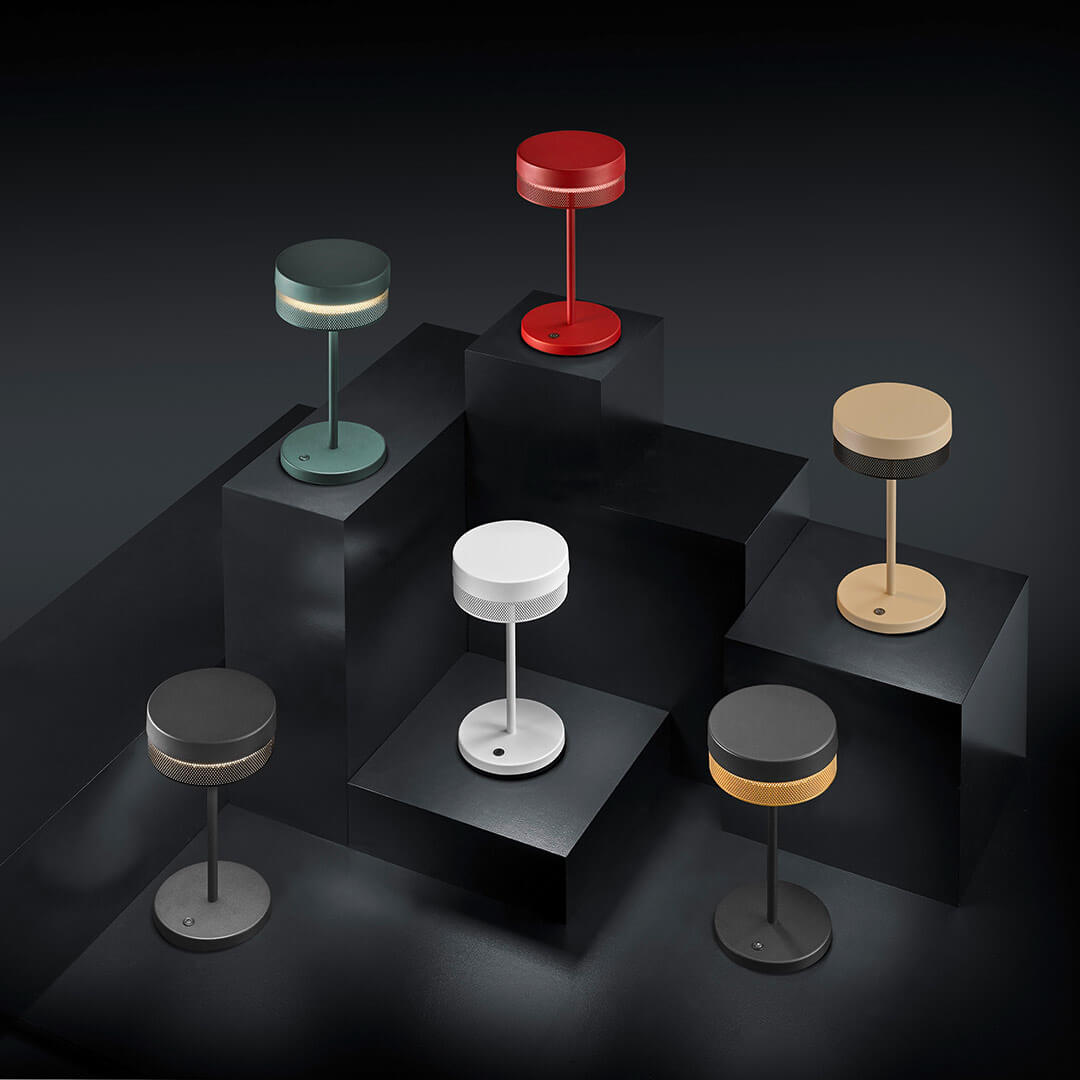Mise en ambiance de six lampes colorées posées sur des socles noirs en escalier
