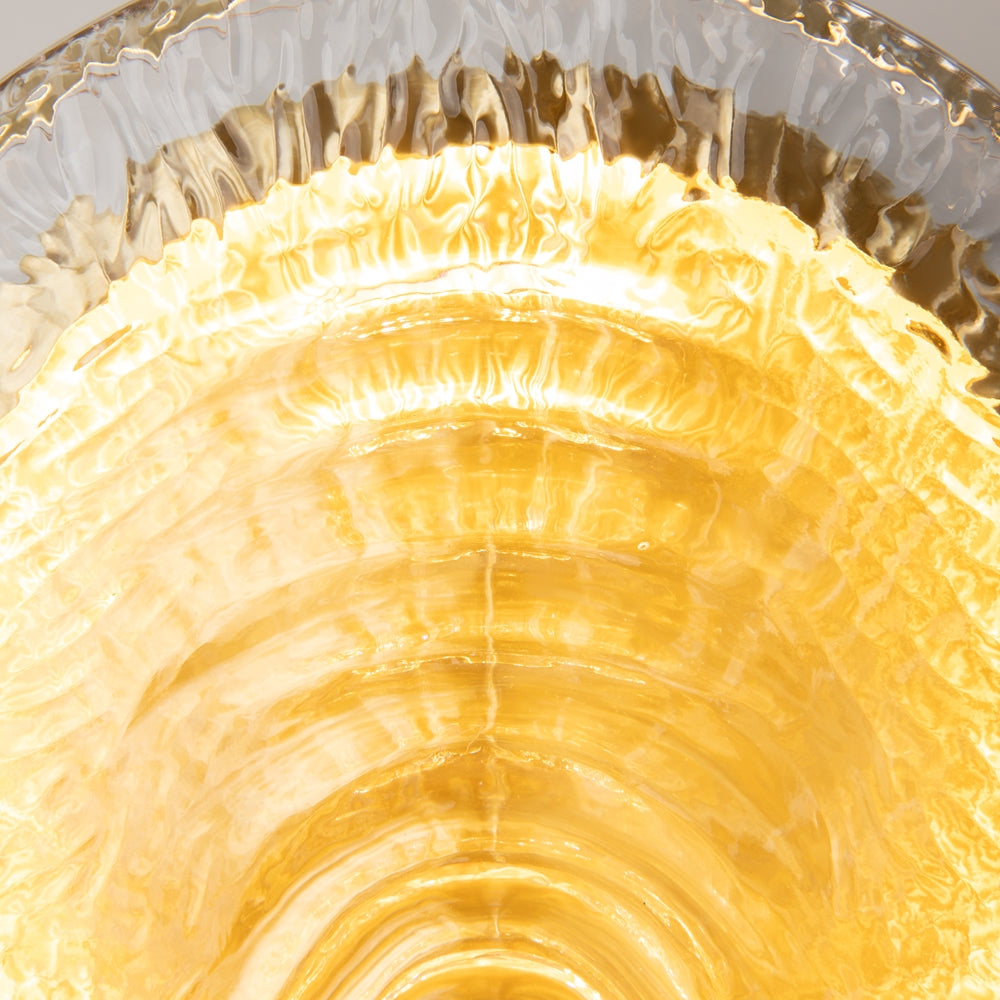 Détail macro du verre martelé et de ses ondulations dorées très lumineuses