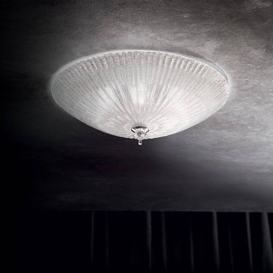 Plafonnier allumé fixé au plafond, halo lumineux dans une pièce sombre