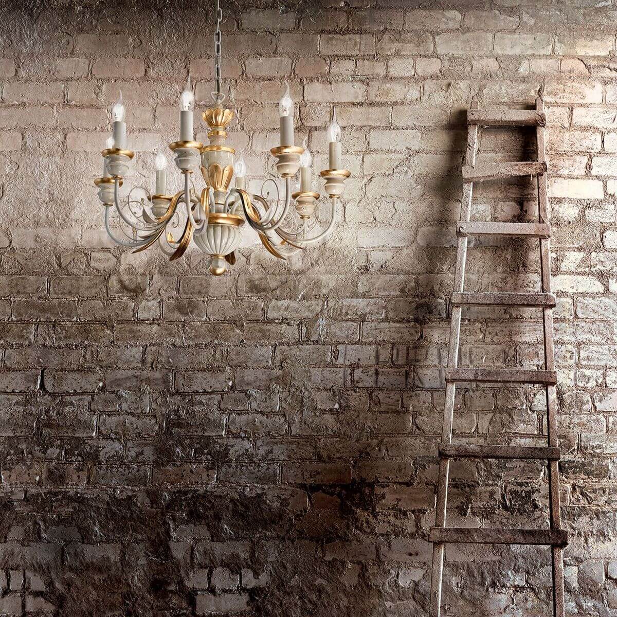 Mise en ambiance rustique : lustre blanc et doré devant un mur de briques et une échelle.