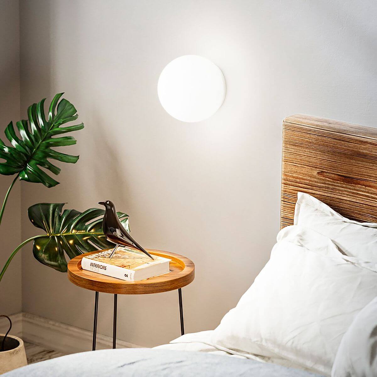 Mise en ambiance de l'applique allumée au-dessus d'une table de chevet en chambre