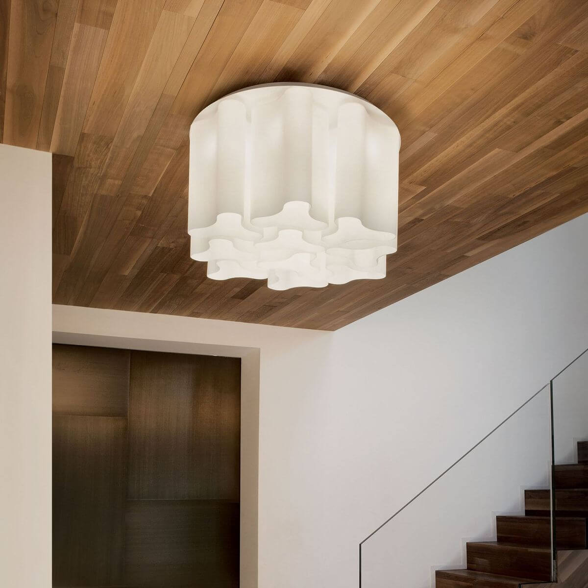 Plafonnier allumé fixé au plafond en bois, ambiance chaleureuse près de l'escalier