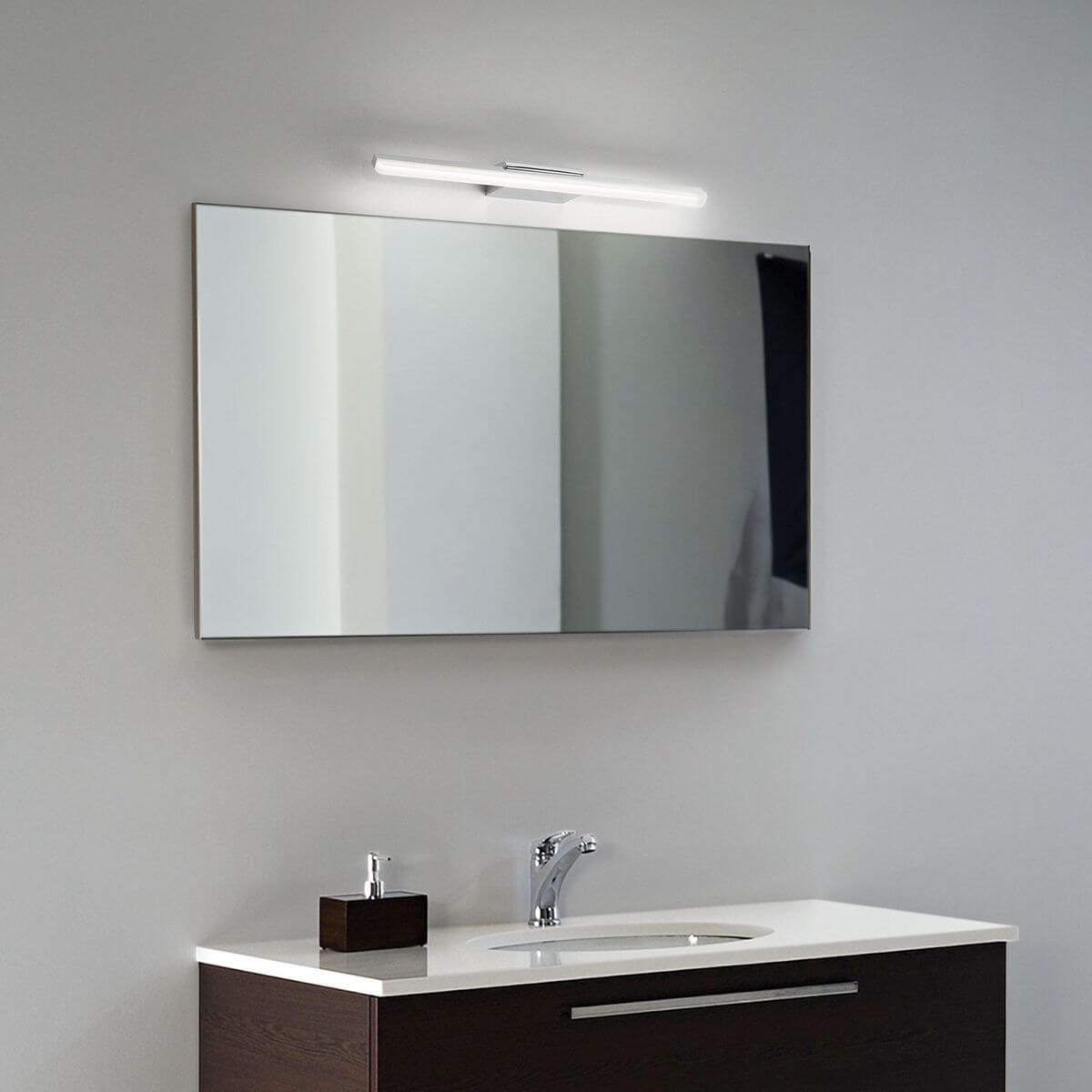 Mise en ambiance de l'applique allumée au-dessus d'un miroir de salle de bain moderne