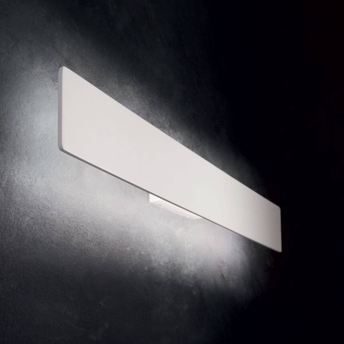 Mise en ambiance sur mur sombre, halo lumineux diffusé vers le haut