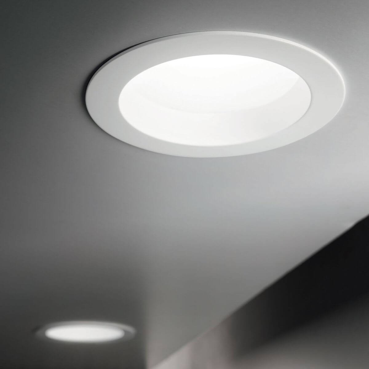 Spot encastrable blanc allumé, intégré dans un plafond gris, ambiance intérieure moderne.