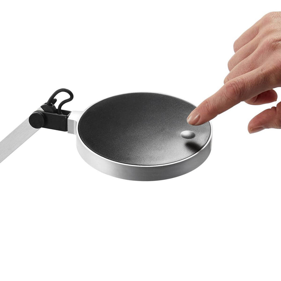 Gros plan sur la tête ronde et l'interrupteur tactile actionné par un doigt.