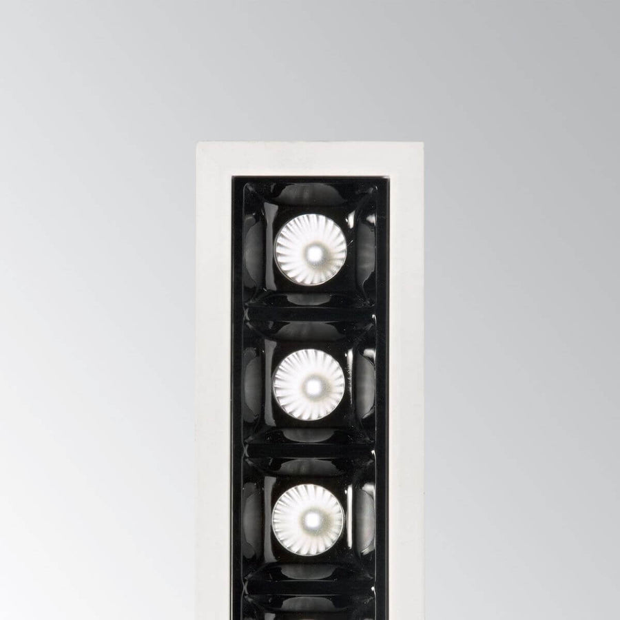Détail rapproché des optiques noires et diffuseurs striés du luminaire