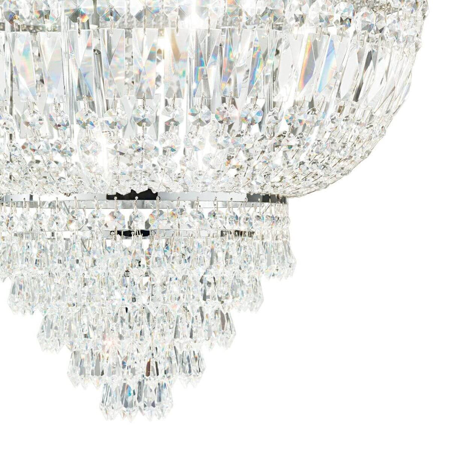 Détail rapproché des prismes et pampilles de cristal sur la structure chromée brillante
