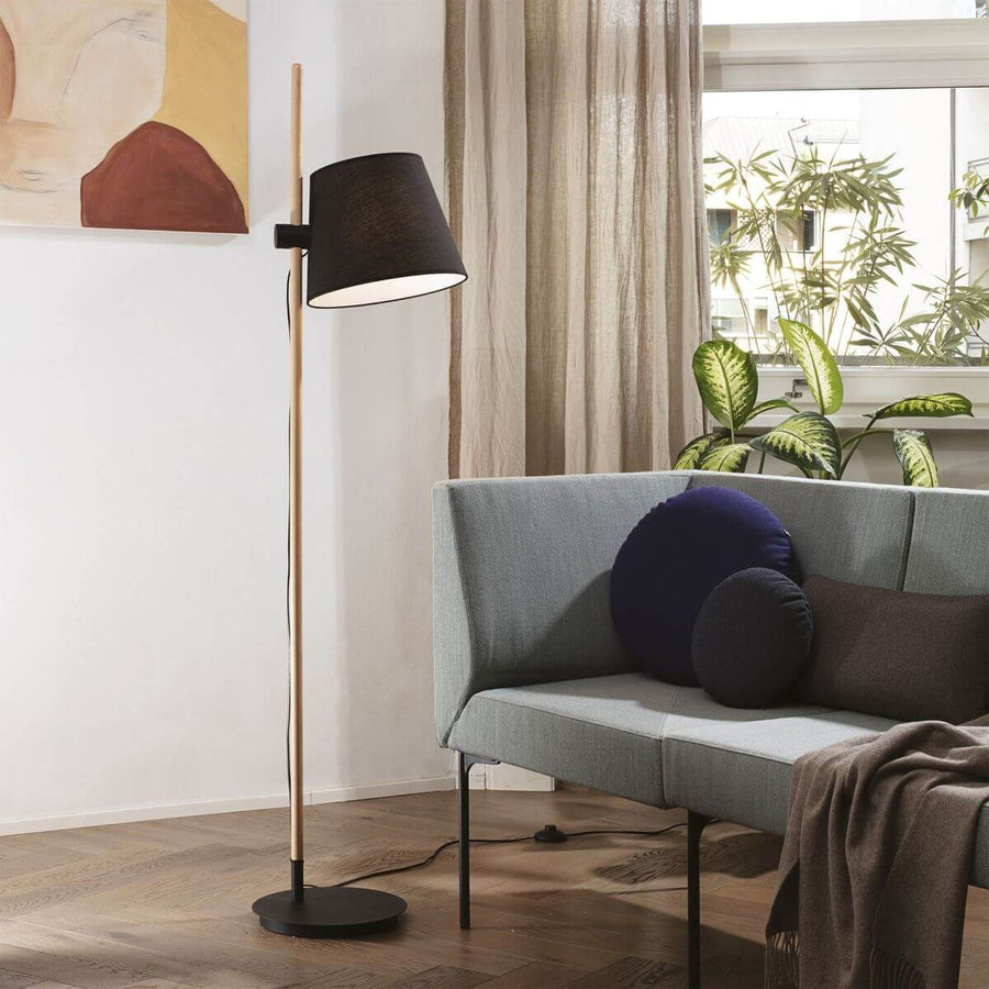 Lampadaire en situation dans un salon près d'un canapé gris