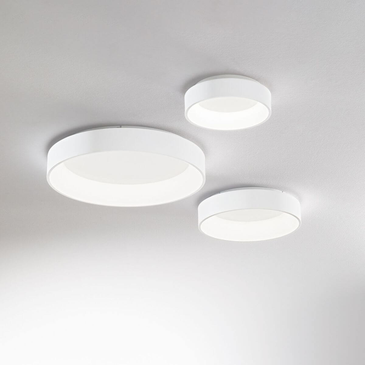 Trois plafonniers blancs ronds fixés au plafond, présentés en trois tailles.