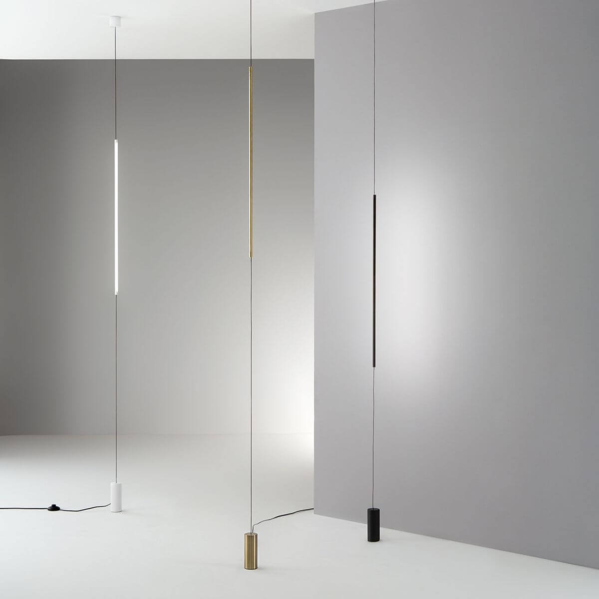Mise en ambiance de trois lampadaires verticaux blanc, laiton et noir