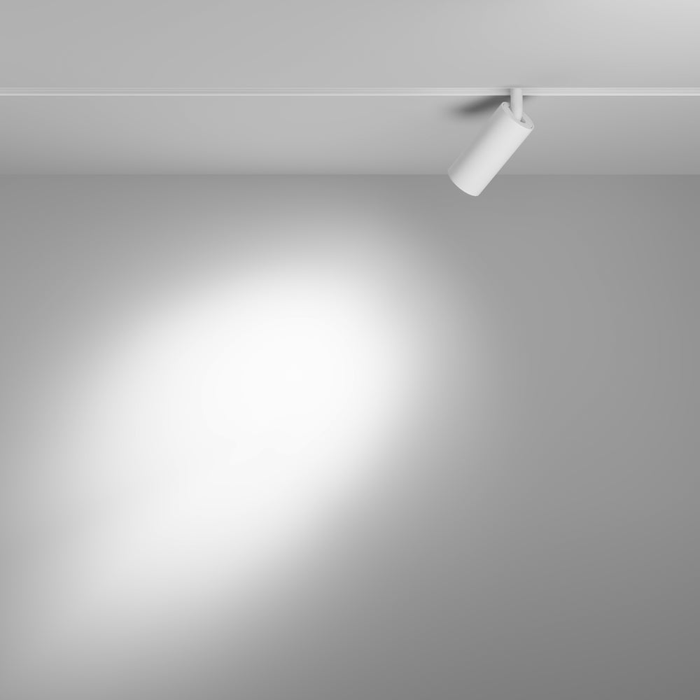 Mise en ambiance : spot sur rail au plafond projetant un faisceau sur un mur