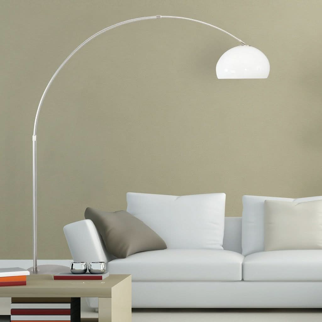 Lampadaire arc blanc installé dans un salon devant un canapé, en ambiance.