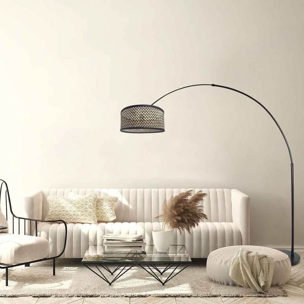 Lampadaire arc installé dans un salon clair au-dessus d'un canapé blanc