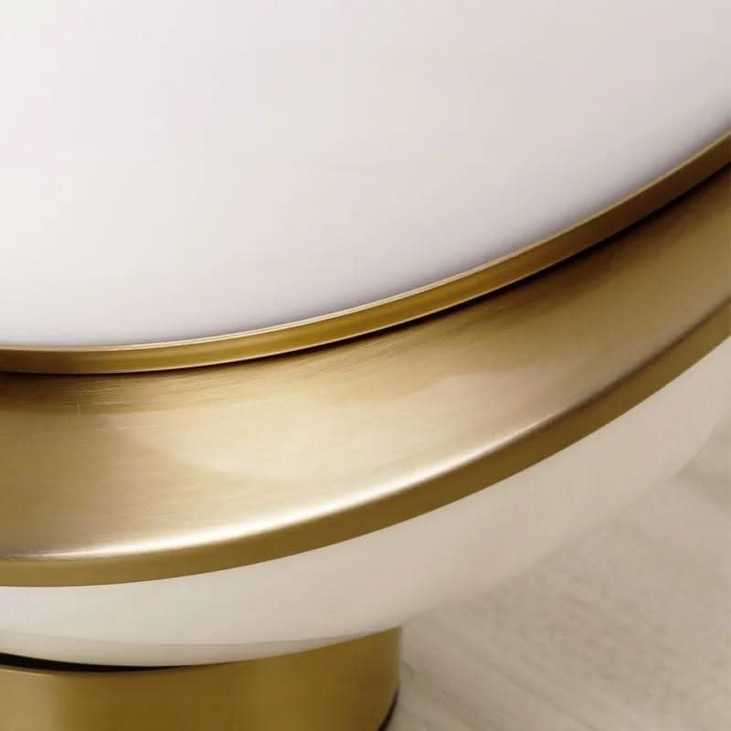 Gros plan sur la finition : cercle en laiton brossé et globe en verre opalin