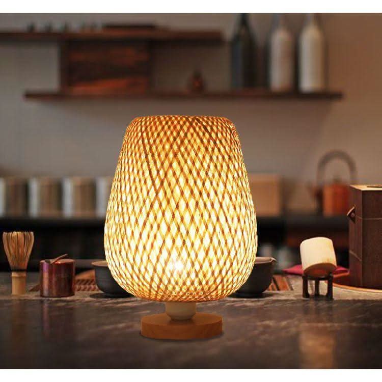 Vue de face du luminaire éclairé, atelier flou avec étagère, bouteilles et bols en arrière-plan