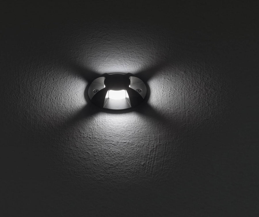 Luminaire encastré allumé sur une paroi grise texturée