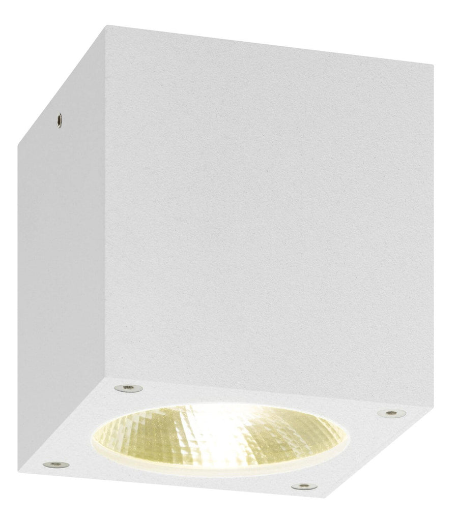 Luminaire allumé vu de dessous, halo doré diffusé par la lentille ronde
