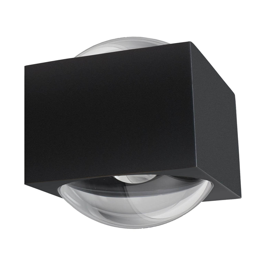 Vue trois quarts sur fond blanc, boîtier carré anthracite et diffuseur bombé transparent.