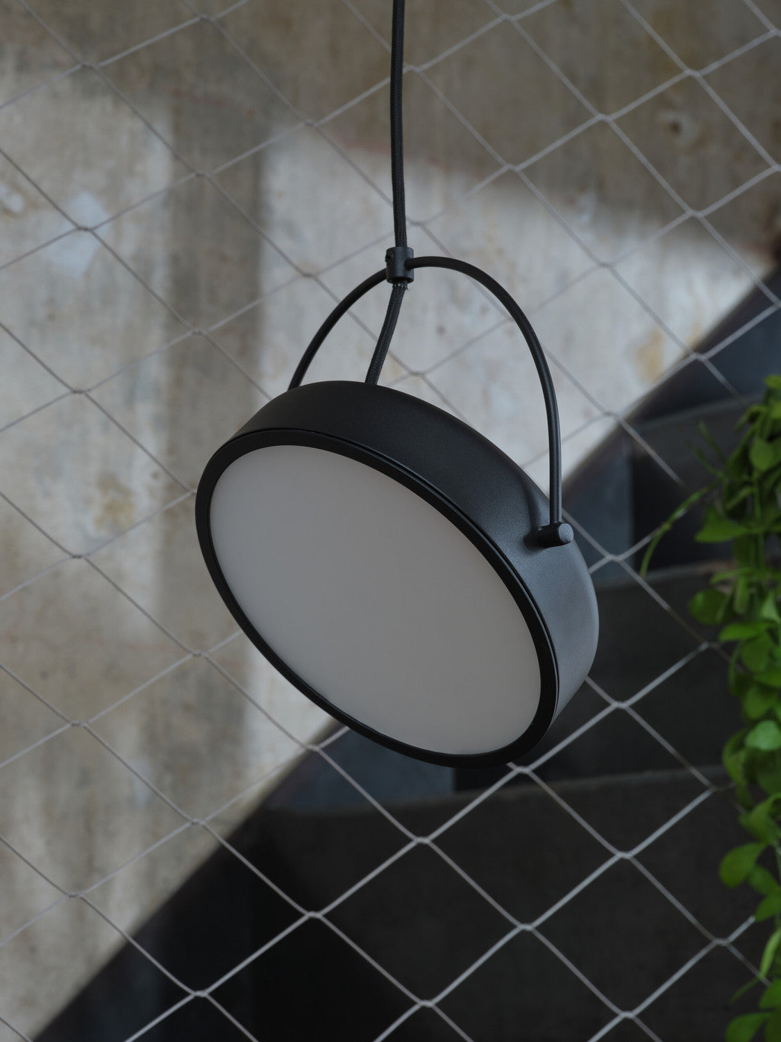 Gros plan sur le luminaire suspendu montrant la finition noire mate du bord.