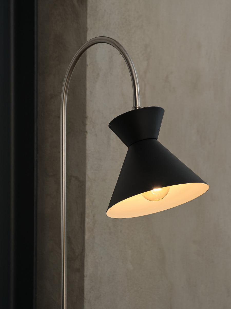 Gros plan sur l'ampoule allumée à l'intérieur de l'abat-jour noir.