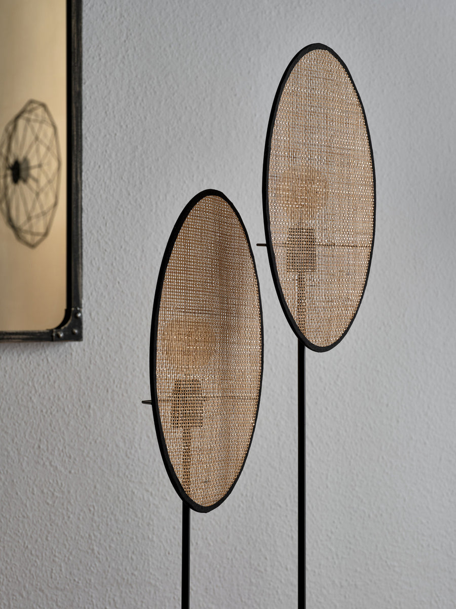 Détail rapproché du cannage beige et de la finition noire des deux disques.