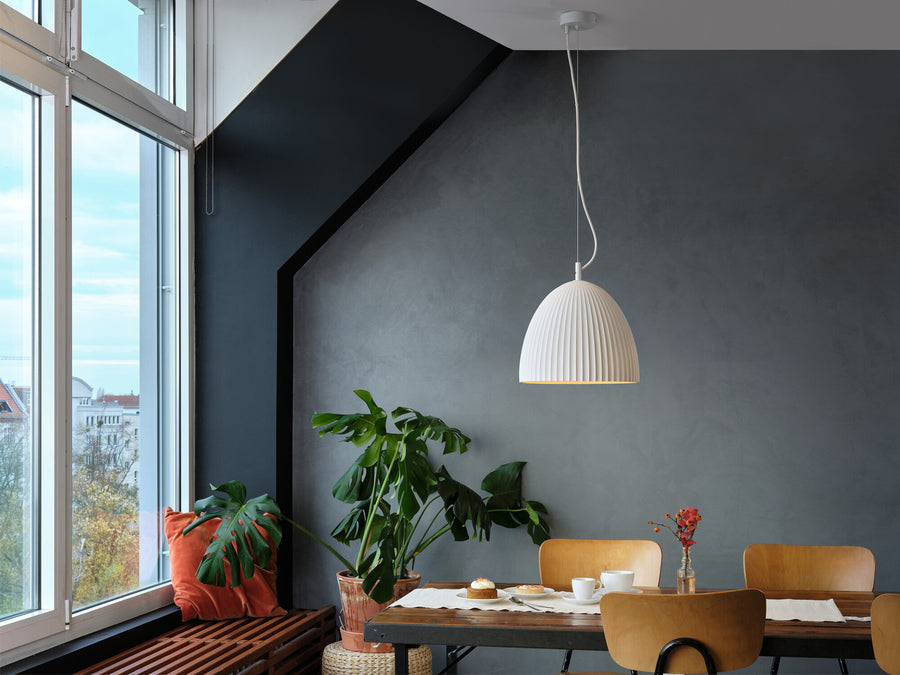 Suspension blanche au-dessus d'une table en bois, dans une salle à manger lumineuse.