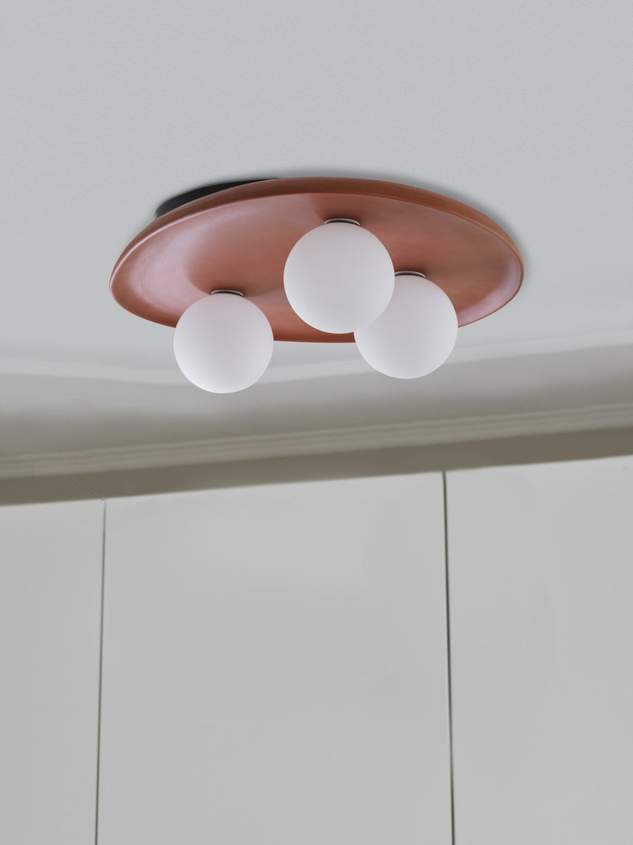 Vue rapprochée du luminaire fixé au plafond, trois sphères blanches
