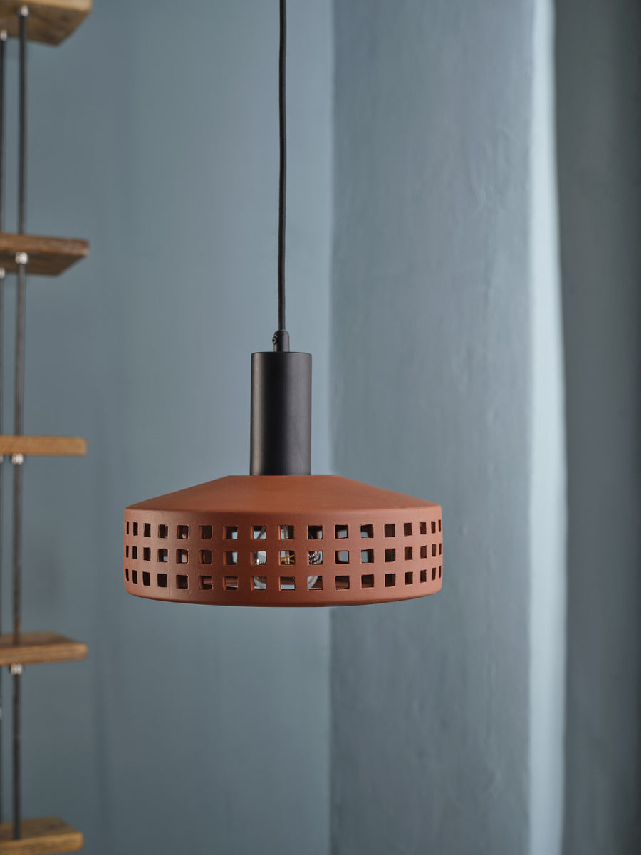Vue rapprochée de la suspension éteinte sur fond de mur bleu.