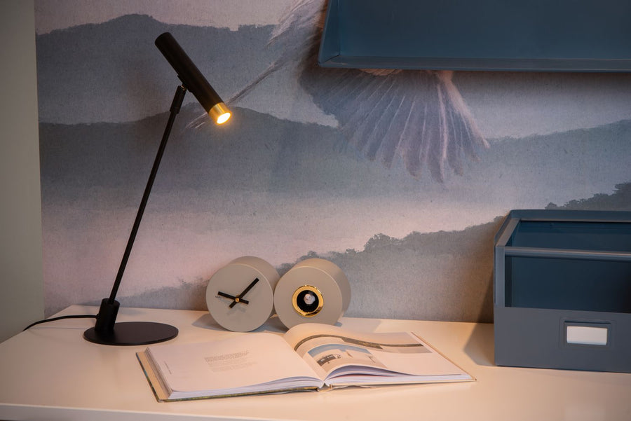 Vue d'ensemble de la lampe sur un bureau devant un papier peint paysage bleu-gris