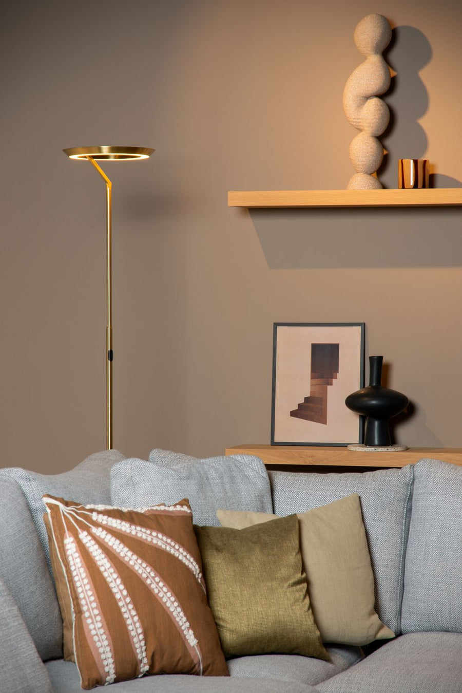Vue rapprochée du lampadaire doré et des coussins sur le canapé